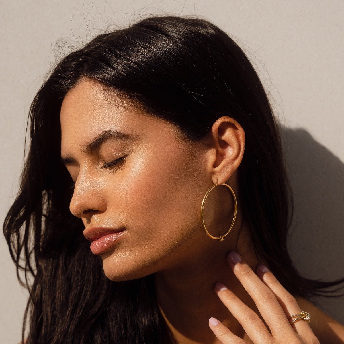 Pendiente de aro con nudo central bañado en oro de 18 quilates